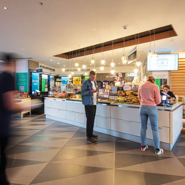 A cafe with two barristas waiting to serve customers